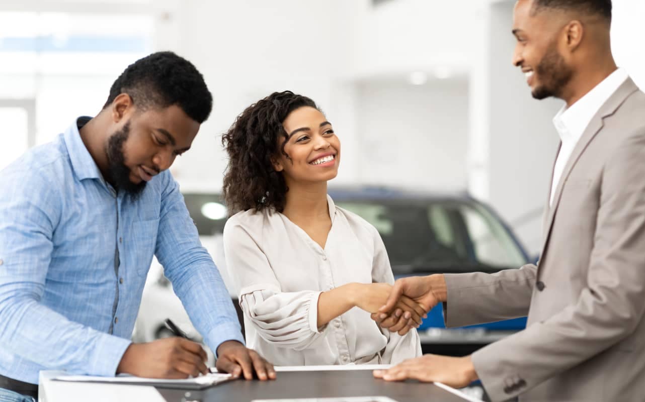 Couple buying a car from a car salesperson