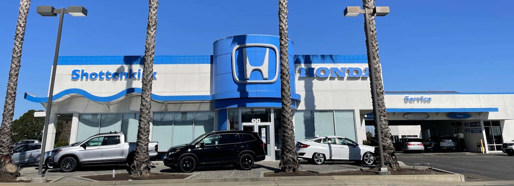 An exterior shot of a Honda dealership at night.