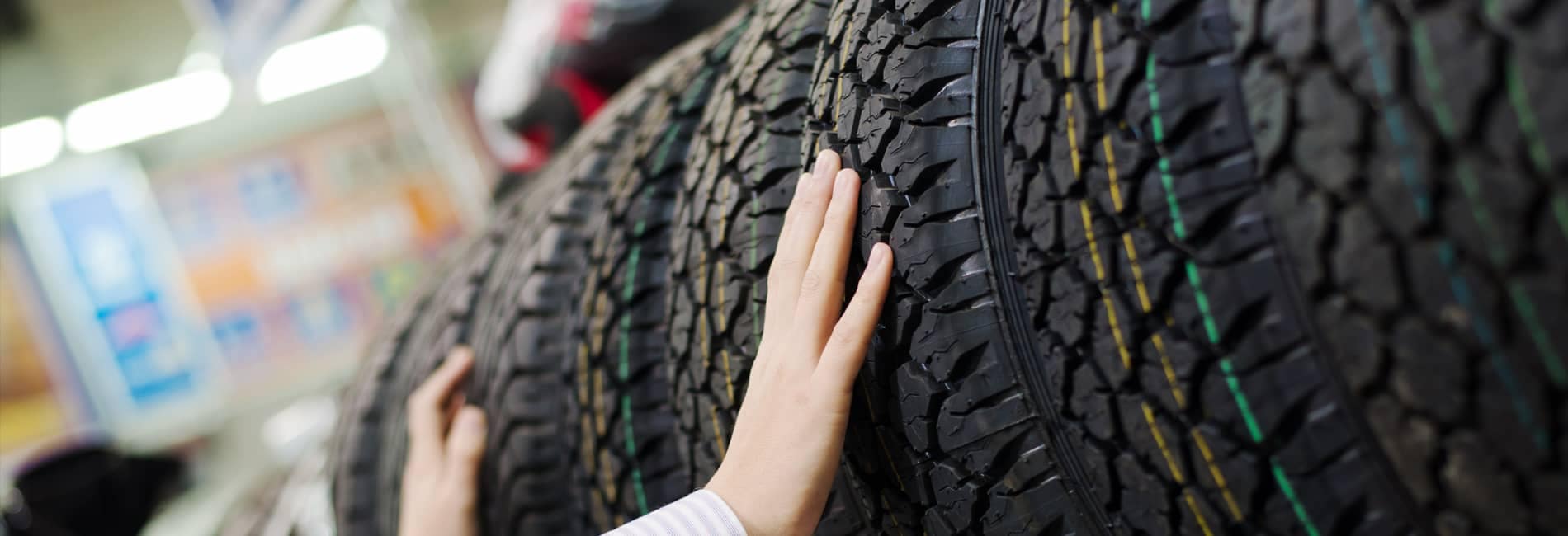 Hands Inspecting Tires in Tire Store