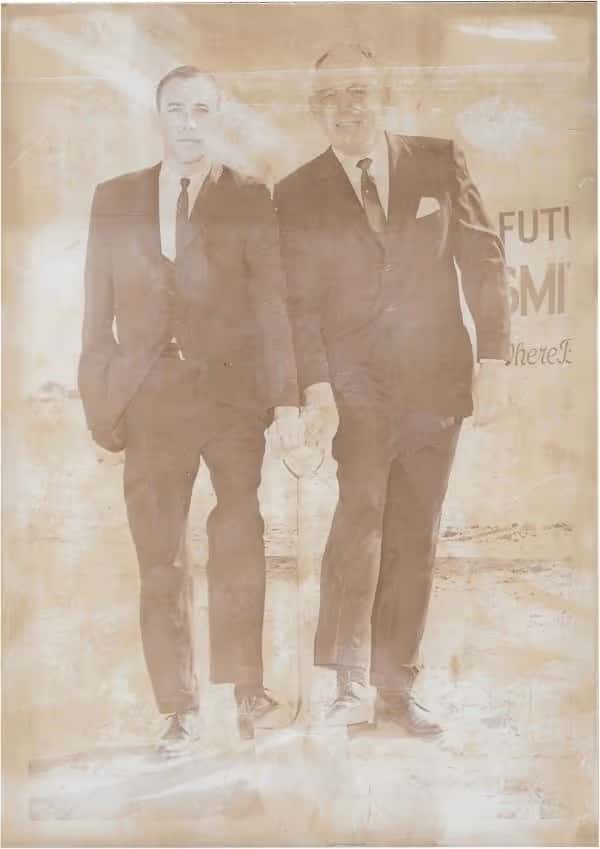 Bill-and-steve-smith-in-suits-with-foot-on-shovel