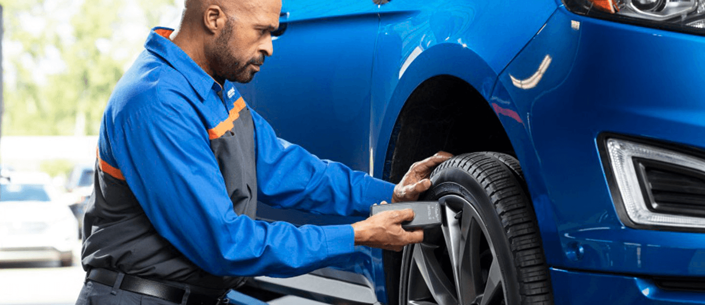 Quick Lane technician checking tire pressure