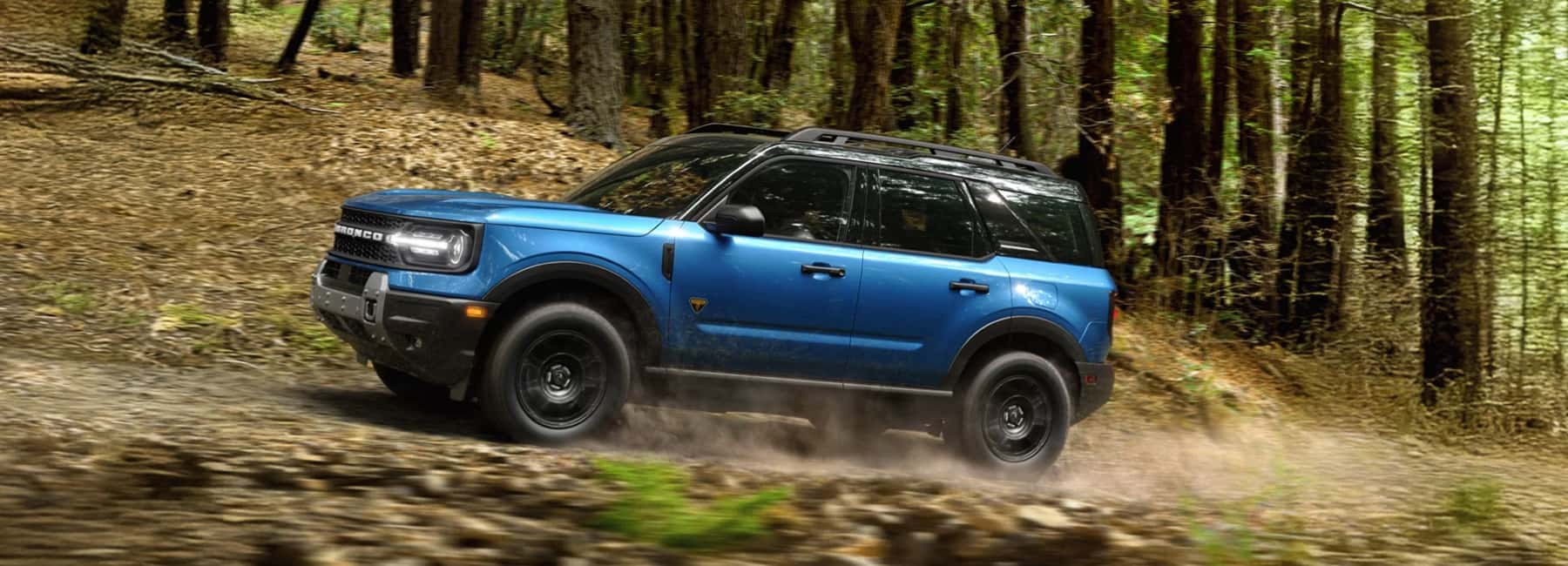 2026-Bronco-Sport-drives-fast-on-forest-path-desktop