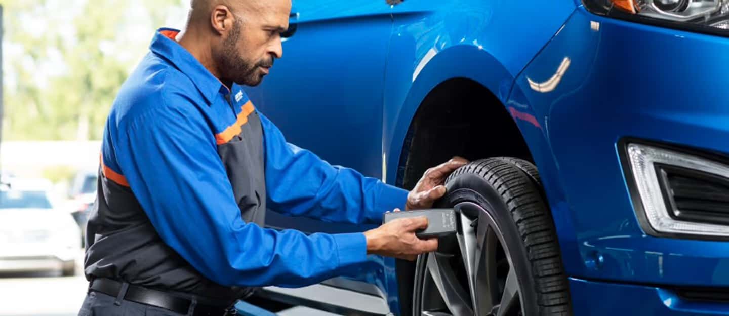 Quick Lane tech checking tire pressure