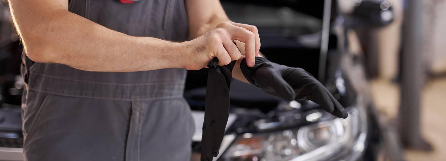 Mechanic donning gloves to work on an engine