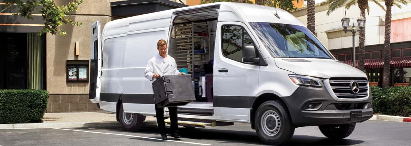 Man-empty-cargo-from-a-sprinter-van.