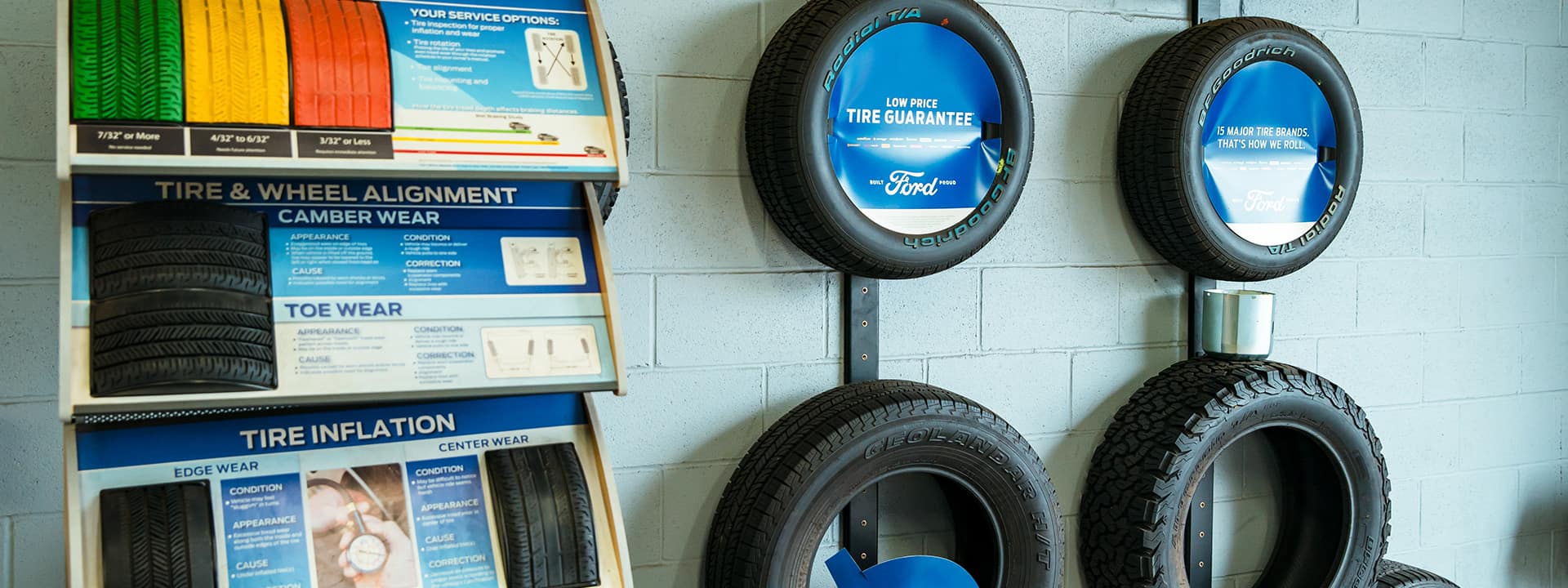 Different types of tires mounted on a wall next to tire information