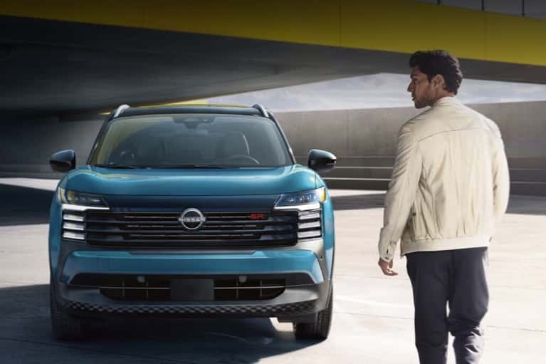 man-walking-toward-2025-Nissan-Kicks-in-rooftop-parking-mobile