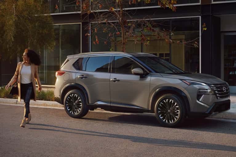 woman-walking-from-parked-2025-Nissan-Rogue-on-city-street-mobile