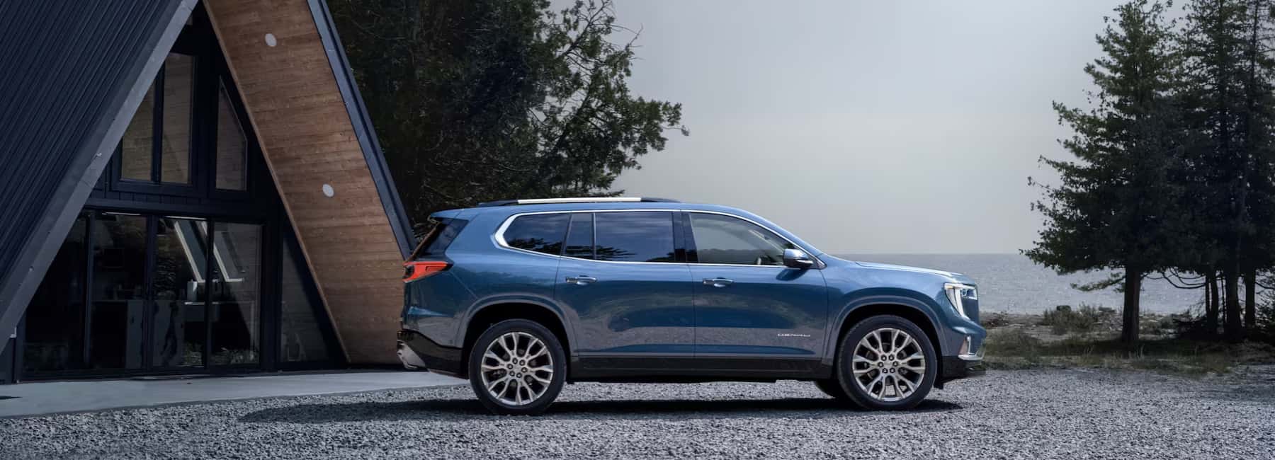 2025 Acadia parked at lakeside house with trees