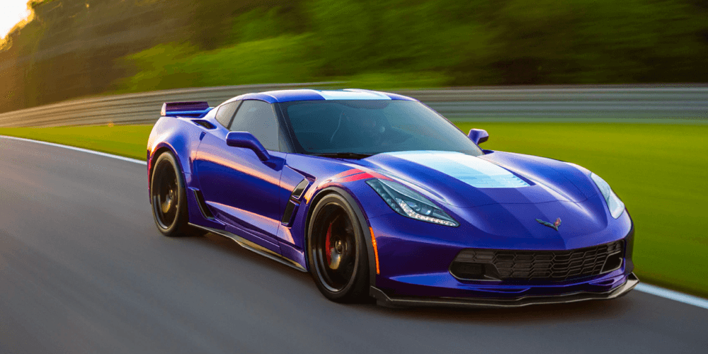 blue Corvette driving on country highway