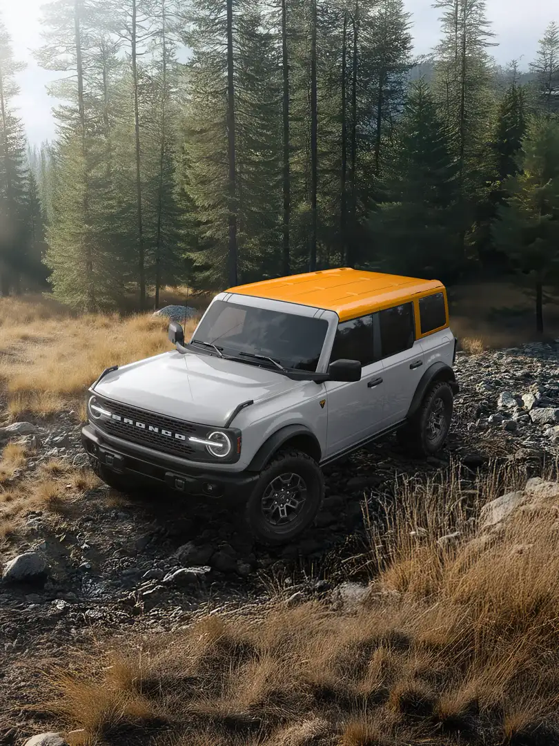 2026 Ford Bronco Badlands with Orange Fury Color Roof traversing offroad in the mountains