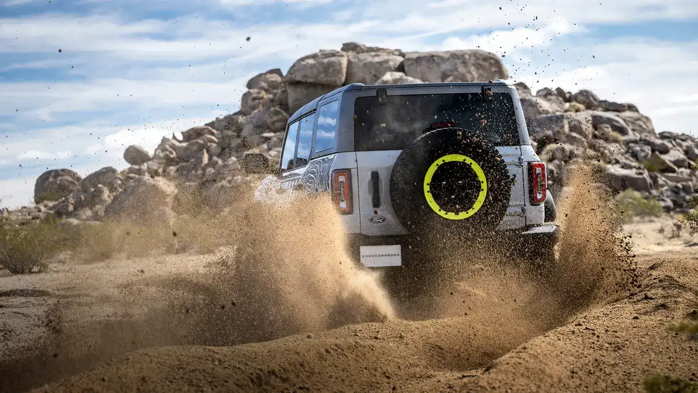 2026 Ford Bronco RTR From the rear driving through a dirt road
