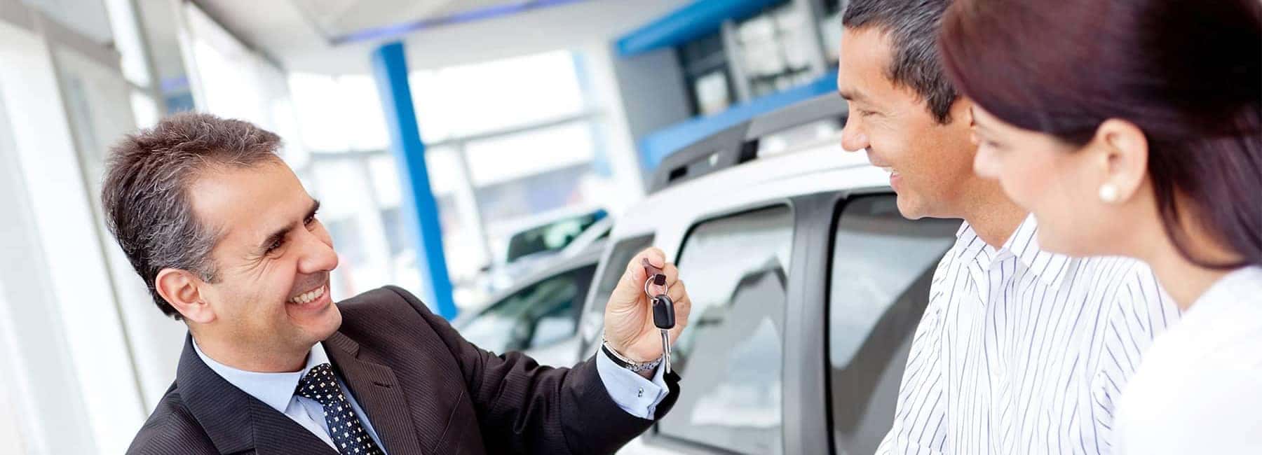 Salesman-Handing-Couple-Car-Keys