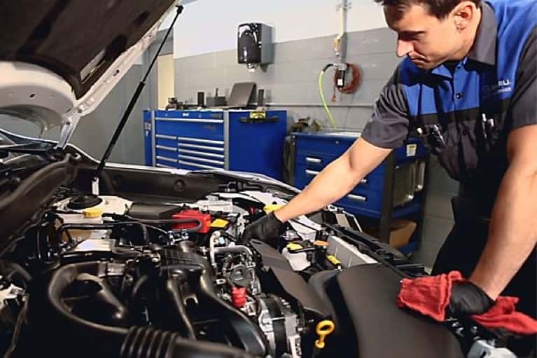 Subaru technician looks at car engine