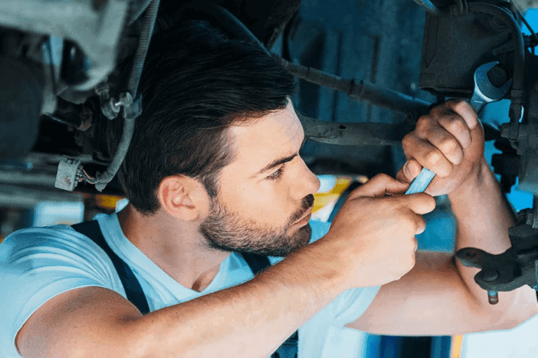 service-man-with-wrench-loosens-bolt-under-car--mobile