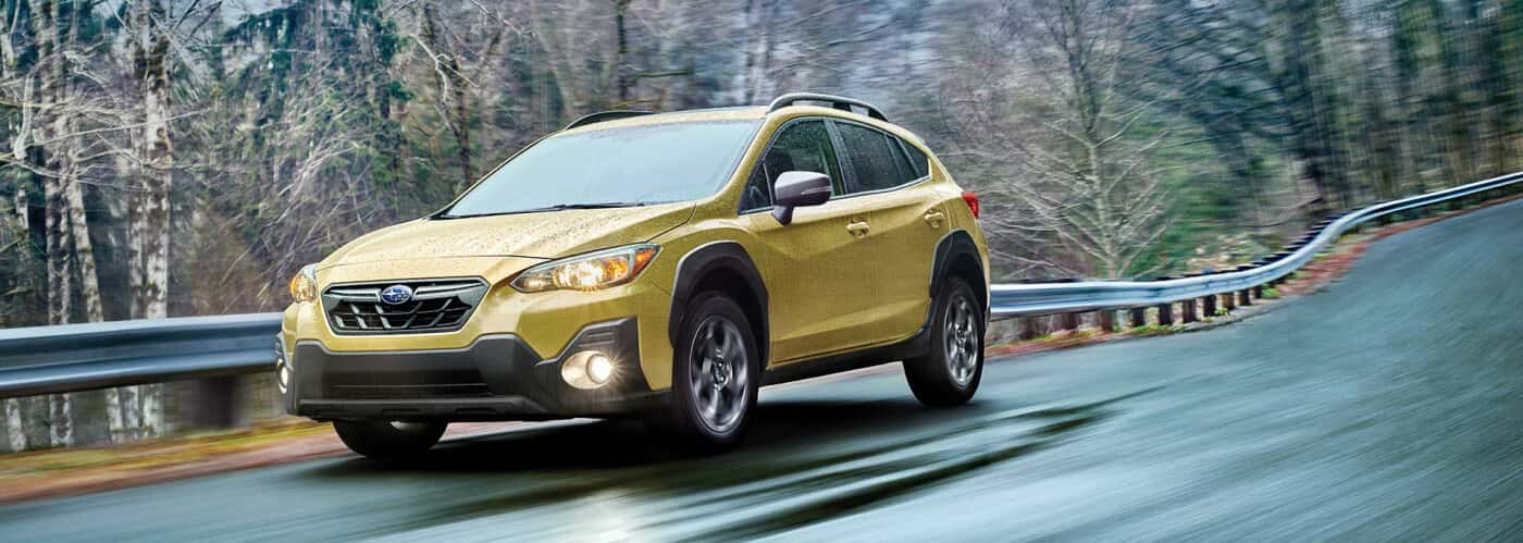 Subaru-Crosstrek-driving-down-a-road-by-white-trees