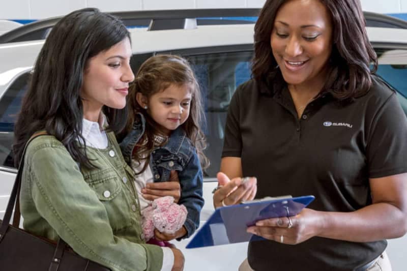 Subaru Advisor discussing options with a female customer and her child