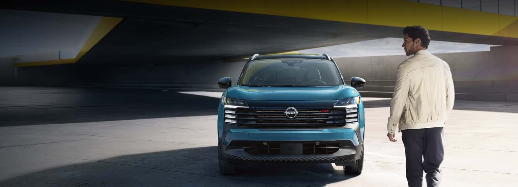 man walking toward 2025 Nissan Kicks in rooftop parking