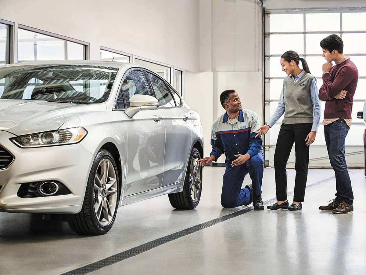 People looking at a car in a service shop