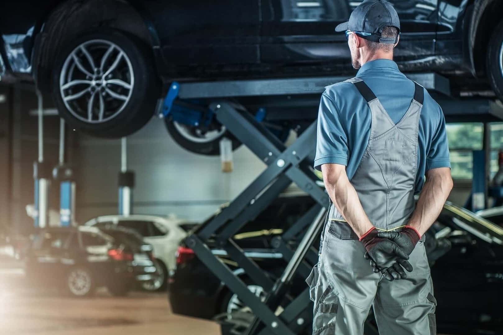 ford service tech lifting vehicle on auto jack