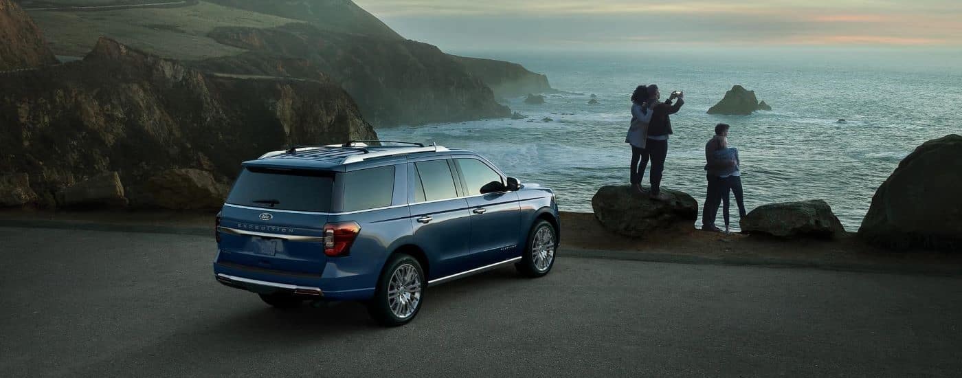 A blue 2023 Ford Expedition is shown overlooking a bay.