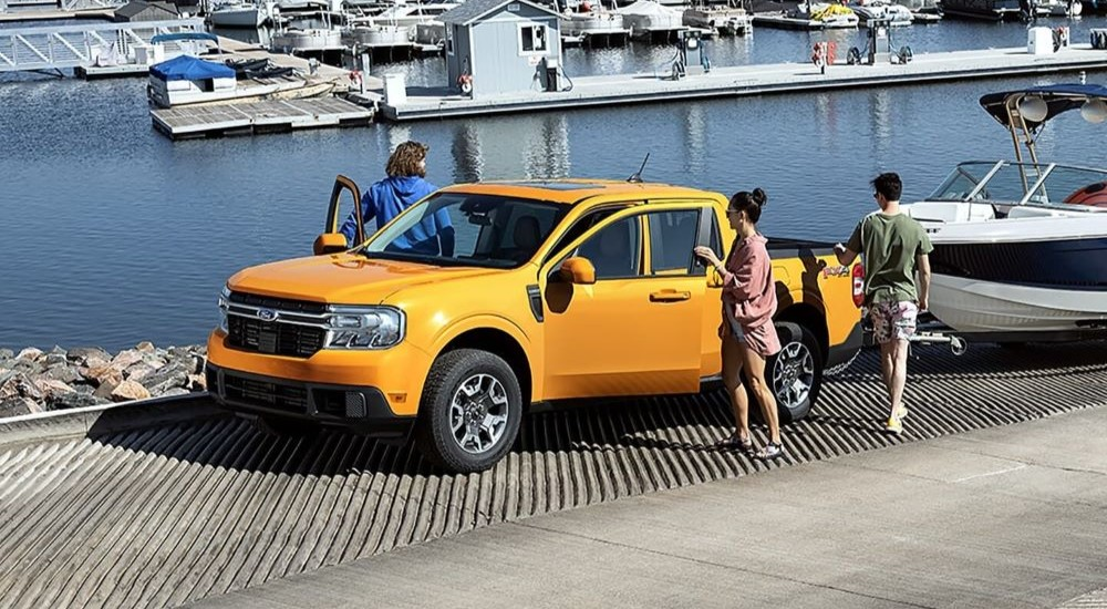 A yellow 2024 Ford Maverick FX4 is shown parked near a harbour.