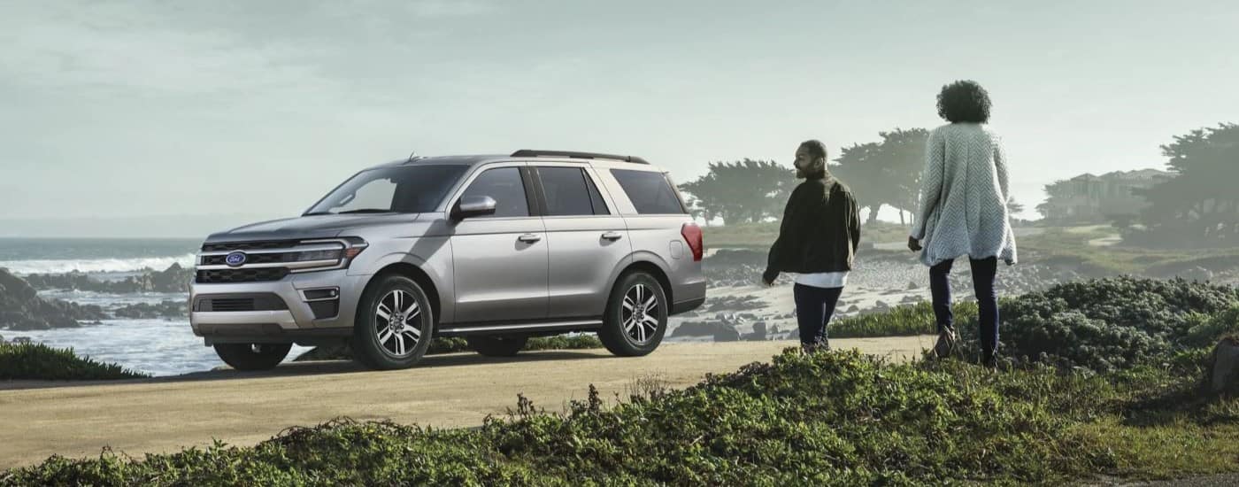 "A couple is shown near a silver 2023 Ford Expedition XLT.