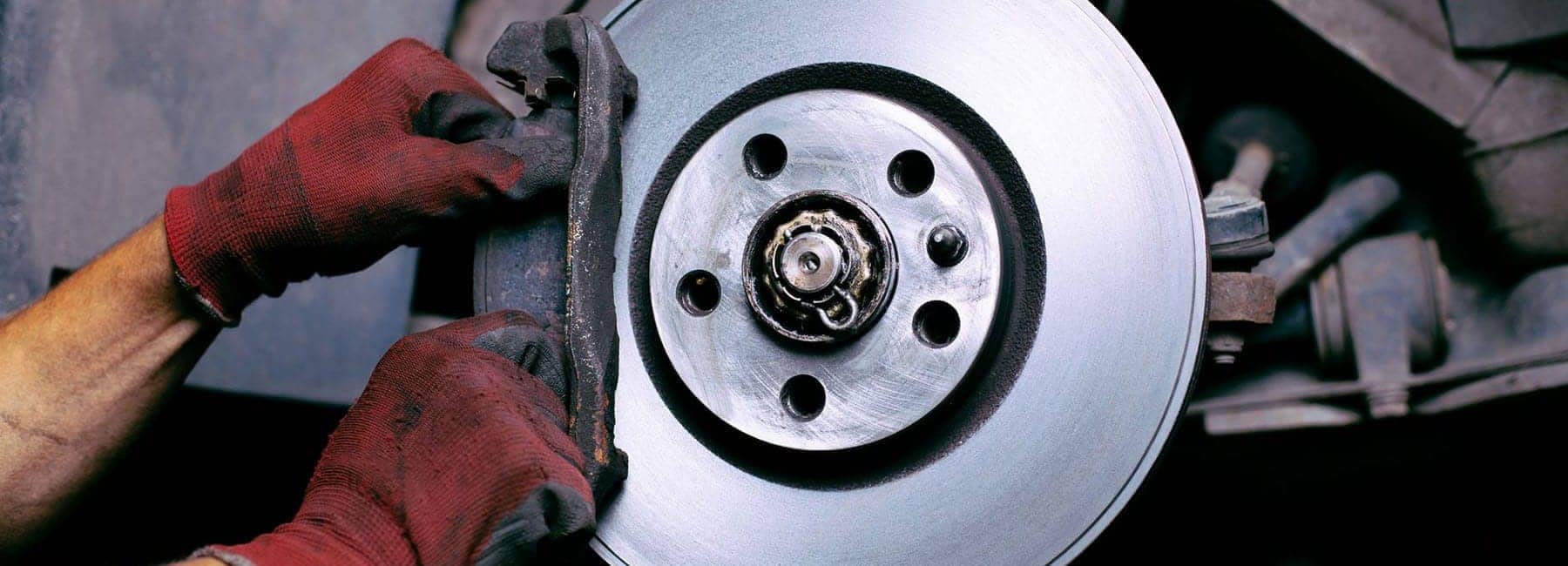 Closeup of a mechanic replacing the brakes on a car