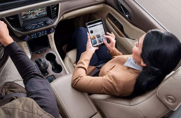 woman_sitting_in_passenger_seat_of_car_enrolling_in_My_GMC_Rewards_on_tablet_o