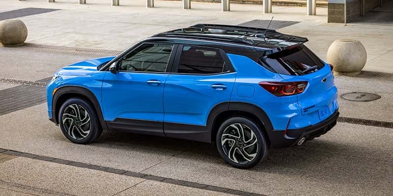 An all-new Powder Blue 2024 Chevy Trailblazer parked in front of a city building. - Toliver Brothers Ballinger, TX