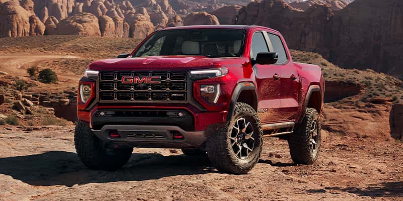 An all-new 2024 Red GMC Canyon parked within a canyon. - Toliver Brothers GM Ballinger, TX