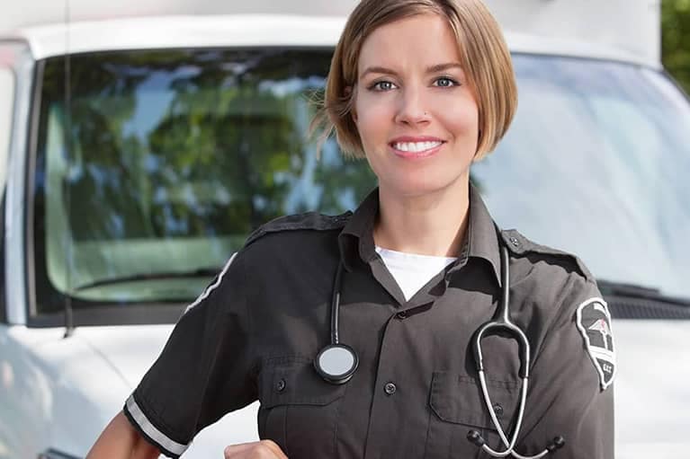Emergency Medical Technician standing in front of an ambulance