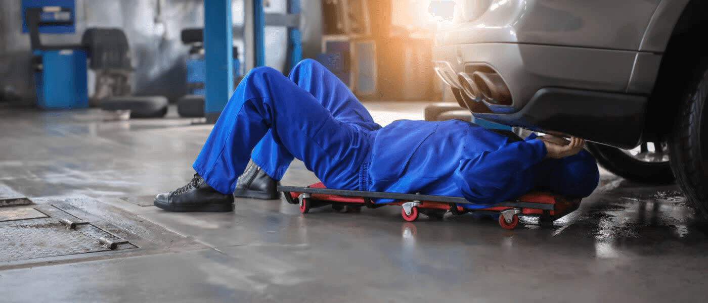 A mechanic underneath a car