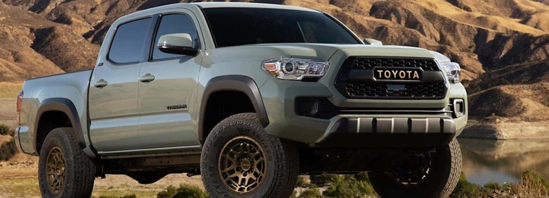 2022tacoma-closeup-front-3qwideshot-lake-hills-in-background-grey