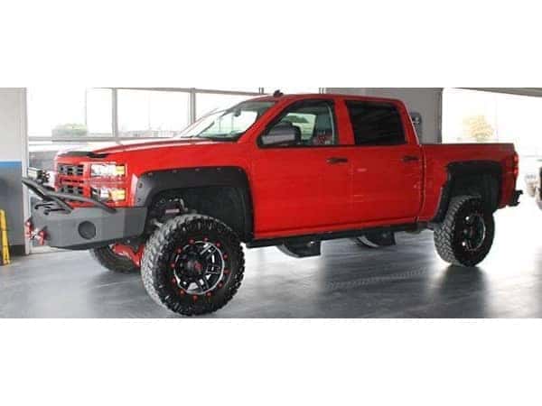 dungeon-garage-slider-14-mobile Red lifted Chevy Truck with Custom grill in front