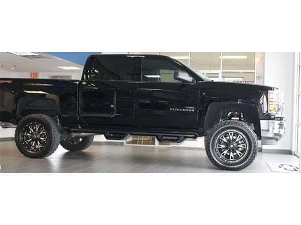 dungeon-garage-slider-7-mobile black Lifted Chevy Truck parked inside the dealership