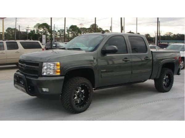 dungeon-garage-slider-9-mobile Dark Green Chevy truck lifted parked outside the dealership
