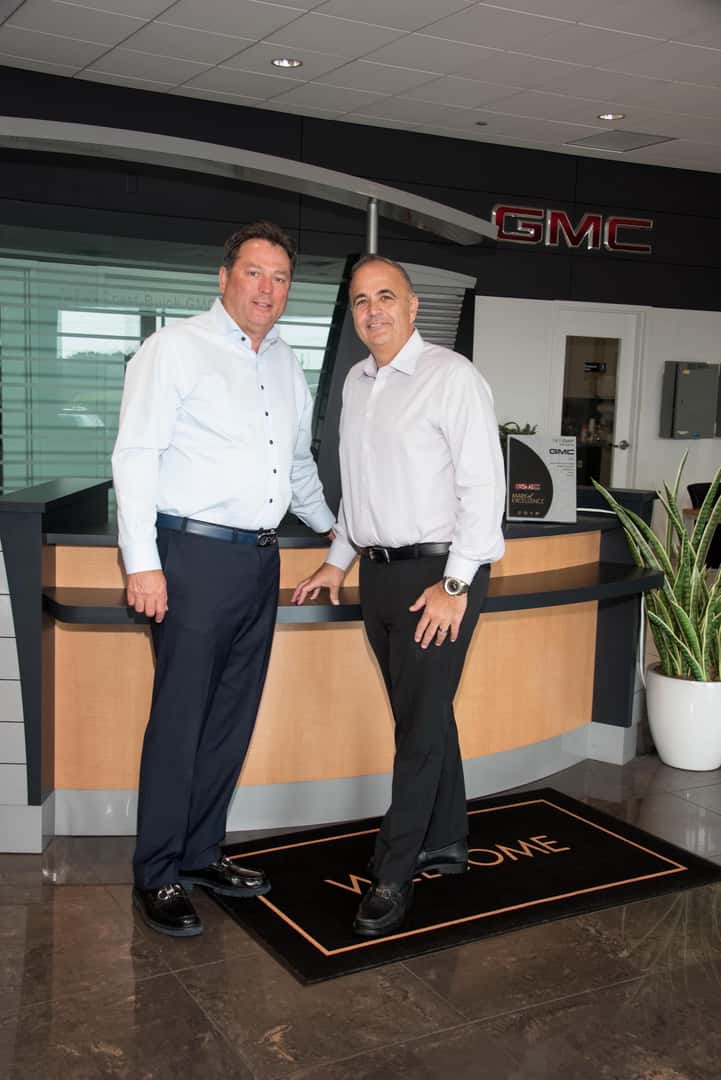 Two dealership employees happily providing customer service