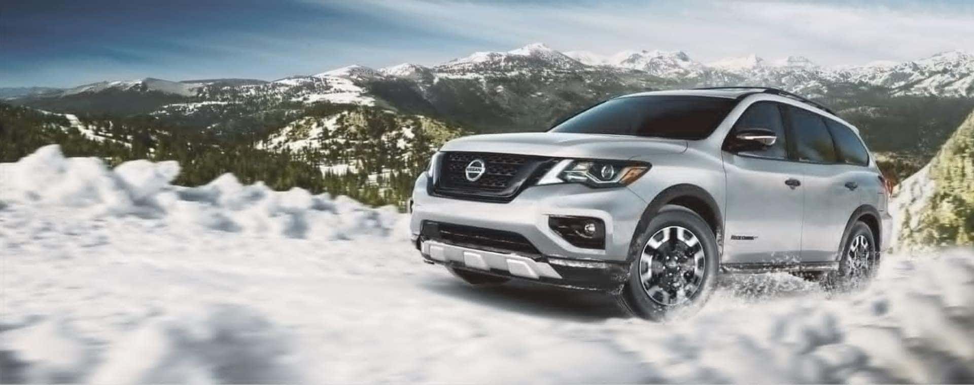 Silver Nissan driving up a mountain