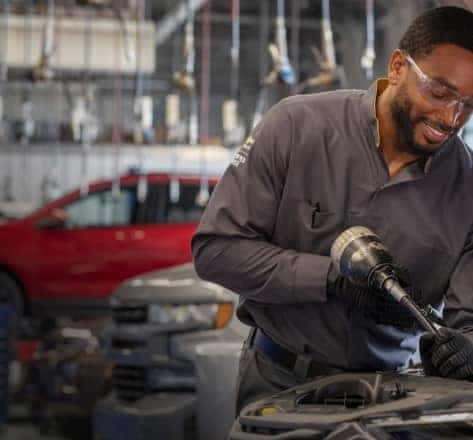 A man working on an engine in an auto shop
