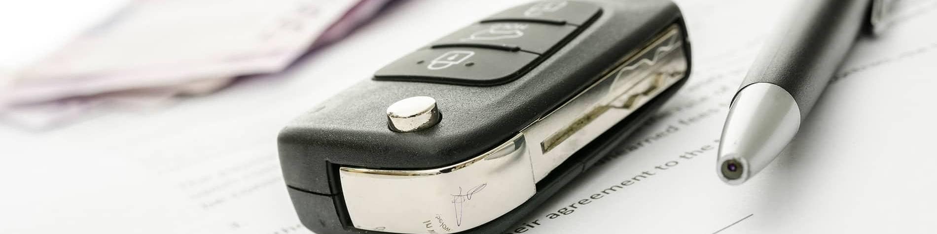 Vehicle keys on top of a financing agreement