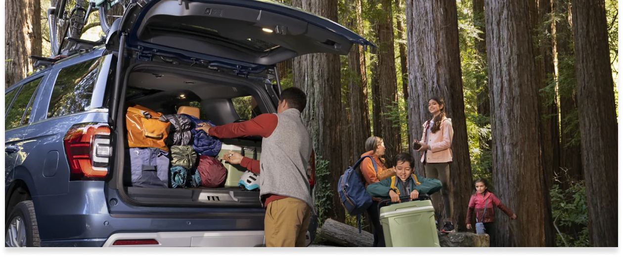 family unloading back of FORD SUV during a camping trip