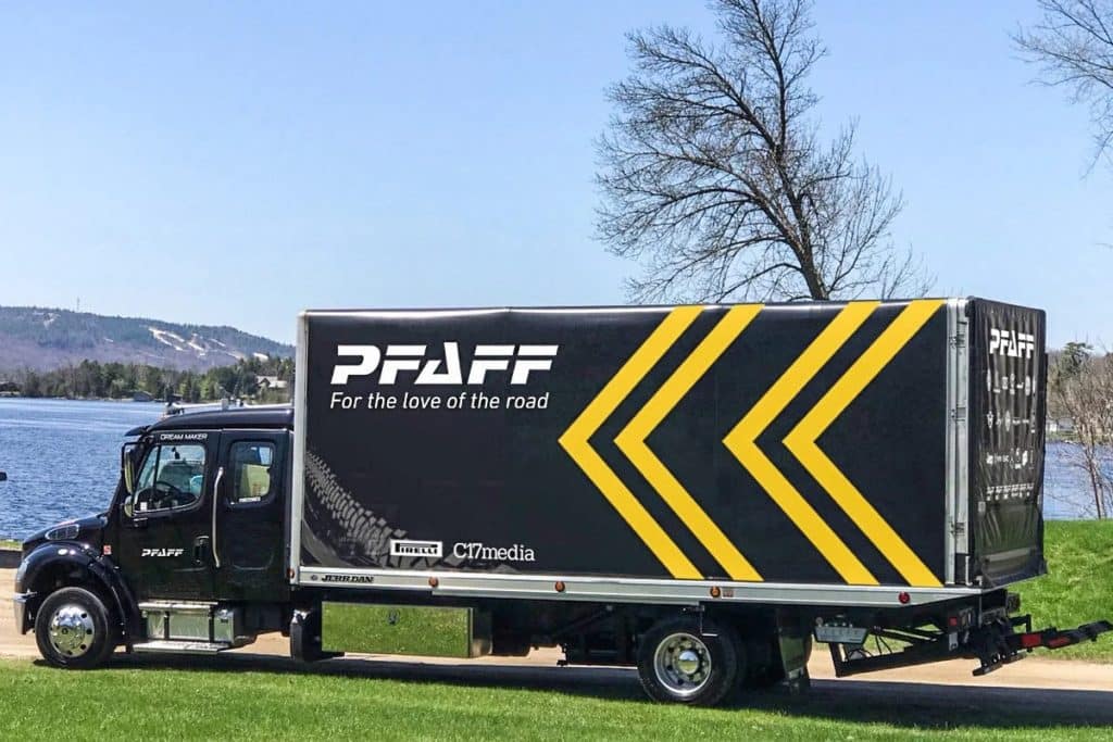 Pfaff delivery truck is driving by a blue body of water