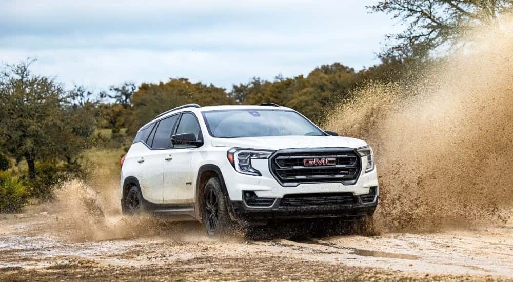 White 2024 GMC Terrain AT4 driving to a GMC dealer