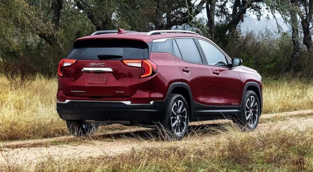 Red 2024 GMC Terrain SLE driving on a dirt path