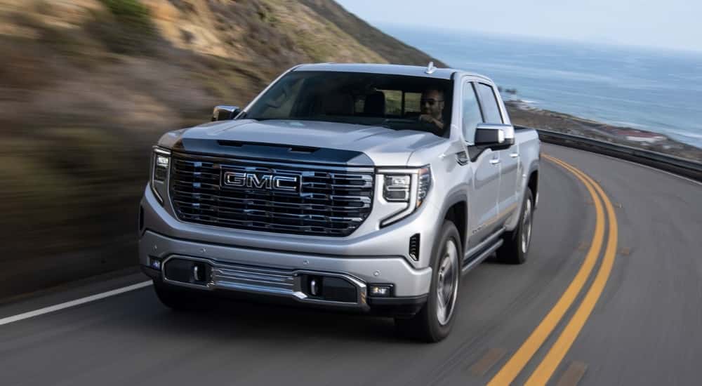 Silver 2024 GMC Sierra 1500 for sale driving on a highway