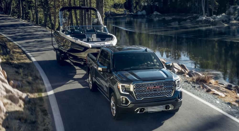 Grey 2021 GMC Sierra1500 towing a boat past a lake