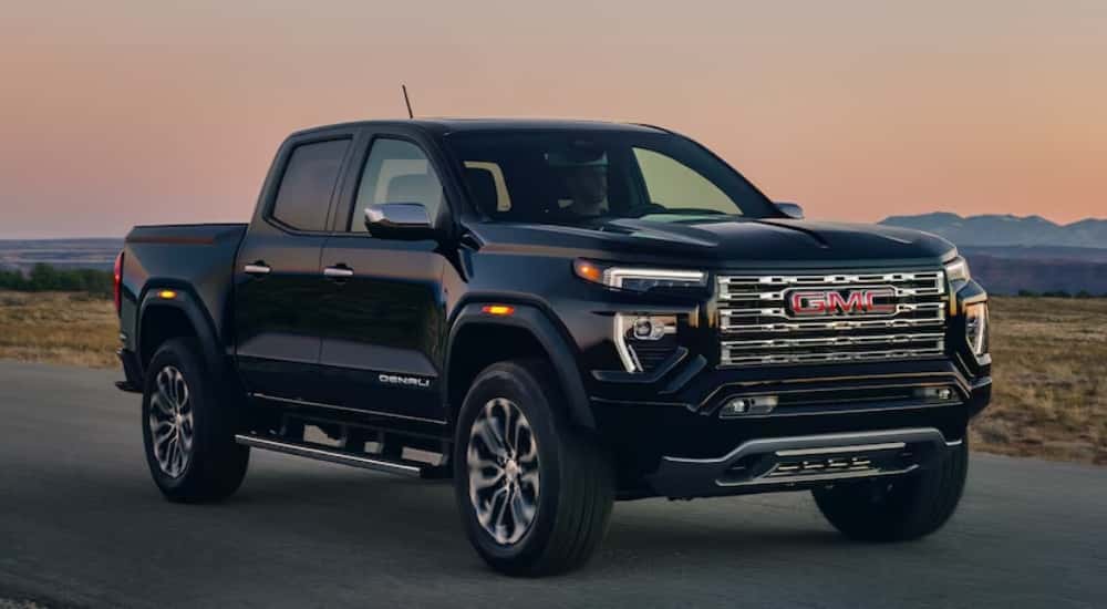 Black GMC Canyon Denali driving down a road