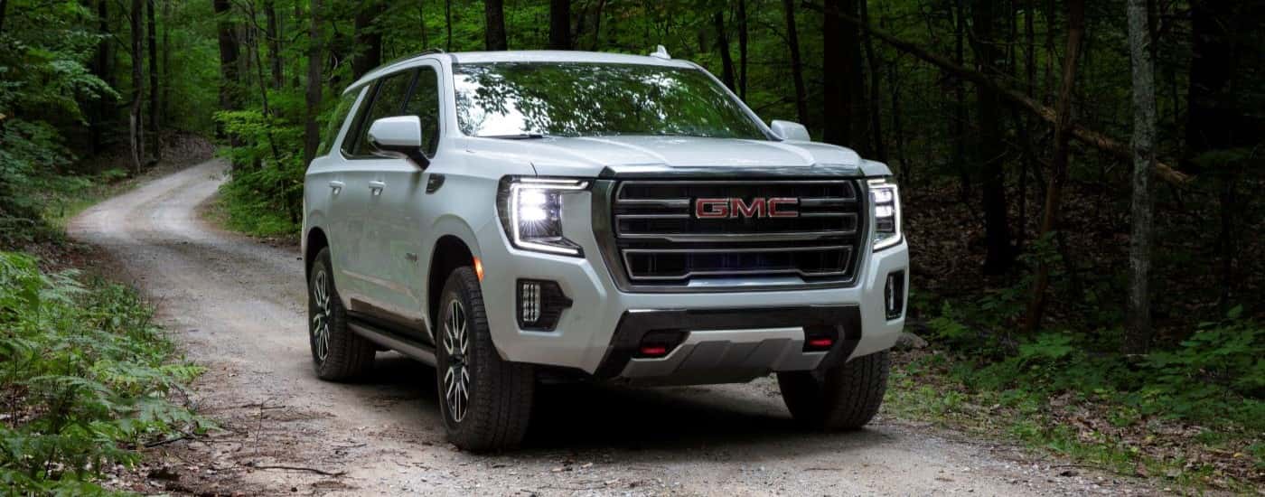 White 2021 GMC Yukon AT4 driving on a trail
