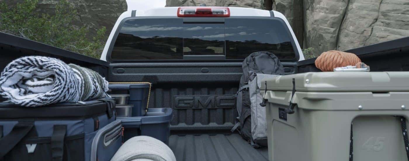 Bed of a white 2026 GMC Canyon filled with equipment